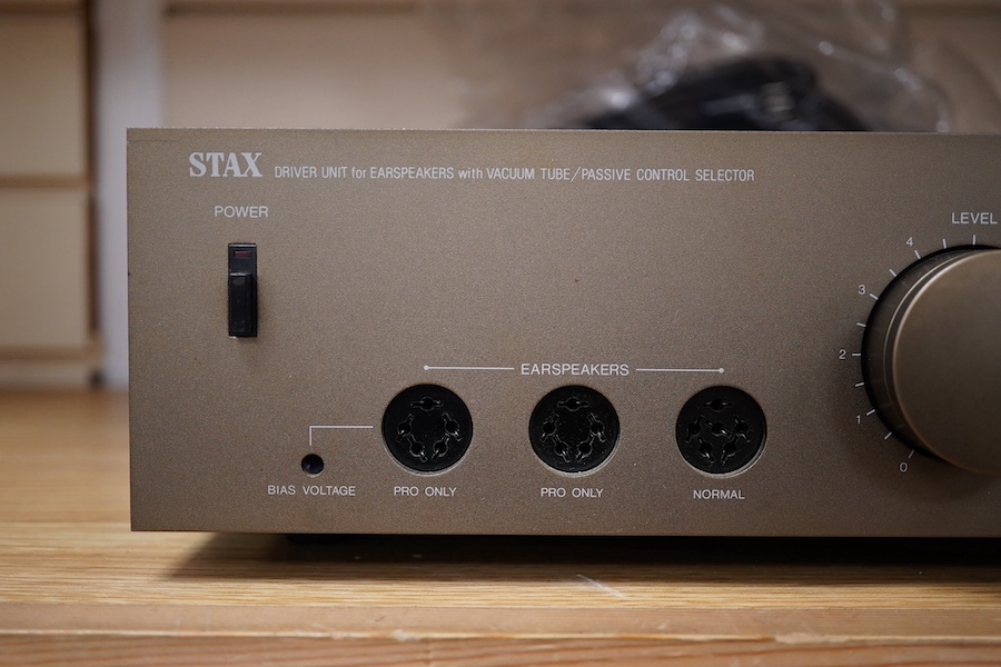 A pair of over-ear Japanese Stax Electrostatic earspeakers, SR-009S, contained within the original wooden box, with outer packaging, owners manual, etc. together with the Stax driver unit for earspeakers with vacuum tube